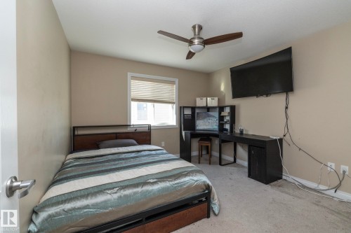 Bedroom featuring a window with blinds, a ceiling fan with integrated lighting, and neutral-toned walls - 151 Caledonia Drive, Leduc, AB - Indoor Photo Showing Bedroom