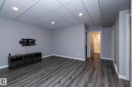 Spacious room featuring wood-finish flooring, recessed lighting, and a drop ceiling - 151 Caledonia Drive, Leduc, AB - Indoor Photo Showing Other Room