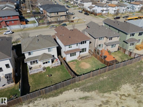 Rear exterior showcasing a neutral-toned siding, attached deck with white railing, and a fenced backyard - 151 Caledonia Drive, Leduc, AB - Outdoor