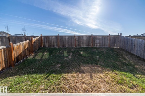 Backyard area featuring a wooden privacy fence, partially covered in a natural wood stain - 151 Caledonia Drive, Leduc, AB - Outdoor