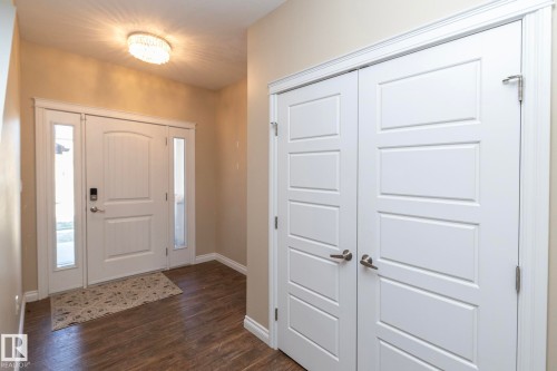 Entryway featuring a panel door with sidelights, wood-finish flooring, and a contemporary ceiling light fixture - 151 Caledonia Drive, Leduc, AB - Indoor Photo Showing Other Room