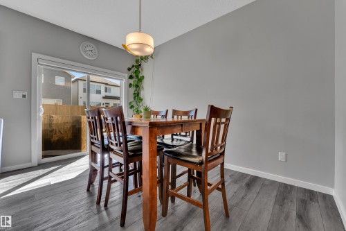 Sliding glass door opening to outdoor space, complemented by a contemporary pendant light fixture - 319 36 Avenue, Edmonton, AB - Indoor Photo Showing Dining Room