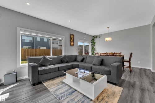 Spacious open-concept living area featuring wood-finish flooring, recessed lighting, and large windows - 319 36 Avenue, Edmonton, AB - Indoor Photo Showing Living Room
