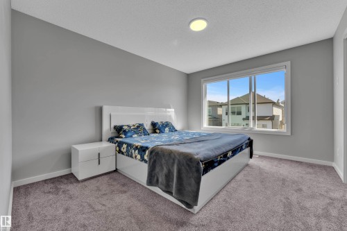 Carpeted room featuring a large window, light gray wall paint, and a flush-mount ceiling light - 319 36 Avenue, Edmonton, AB - Indoor Photo Showing Bedroom