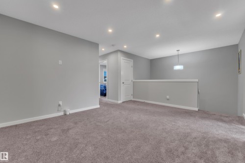 Carpeted open loft area featuring recessed lighting, a contemporary pendant light fixture, light gray wall paint, and white trim - 319 36 Avenue, Edmonton, AB - Indoor Photo Showing Other Room
