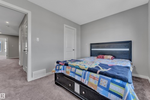 Carpeted room featuring light gray walls, white baseboards, and white interior doors with dark hardware - 319 36 Avenue, Edmonton, AB - Indoor Photo Showing Bedroom