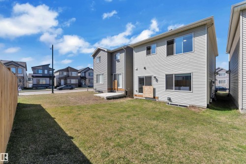 Spacious backyard with a wooden privacy fence, a concrete patio, and a two-story exterior featuring light grey siding - 319 36 Avenue, Edmonton, AB - Outdoor