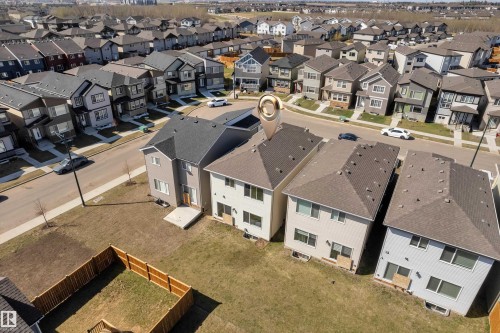 Aerial perspective of a contemporary two-story home with a dark shingle roof, light-colored siding, and a concrete patio - 319 36 Avenue, Edmonton, AB - Outdoor