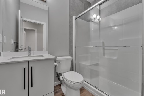 Bathroom featuring a white vanity with an integrated sink, polished chrome faucet, and rectangular mirror - 319 36 Avenue, Edmonton, AB - Indoor Photo Showing Bathroom