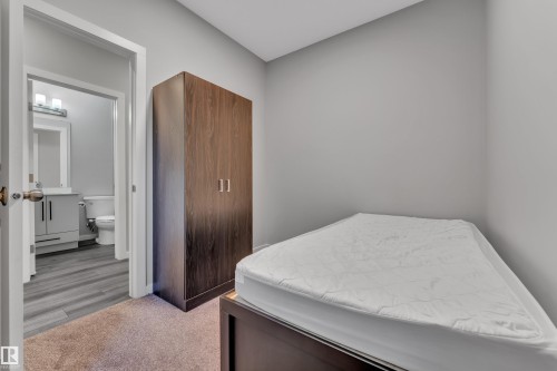 Neutral gray wall finishes complementing a built-in wardrobe with wood-look doors - 319 36 Avenue, Edmonton, AB - Indoor Photo Showing Bedroom