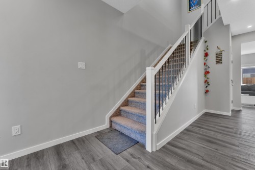 Staircase featuring carpeted treads, white risers, and a railing with black metal balusters and a white newel post - 319 36 Avenue, Edmonton, AB - Indoor Photo Showing Other Room