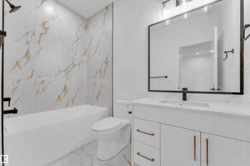 Modern bathroom featuring a white vanity with gold-tone hardware, a rectangular undermount sink, and a black-framed mirror - 173 Graybriar Drive, Stony Plain, AB - Indoor Photo Showing Bathroom