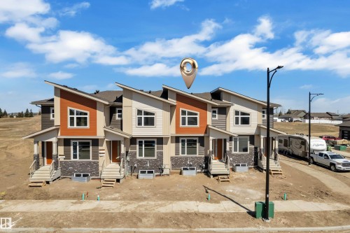 Modern townhome exteriors featuring multiple material finishes, sloped rooflines, and individual front porches - 173 Graybriar Drive, Stony Plain, AB - Outdoor With Facade