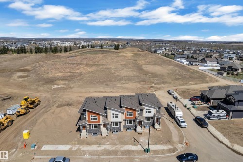 Contemporary townhomes featuring multi-tone siding, contrasting trim, and distinct rooflines - 173 Graybriar Drive, Stony Plain, AB - Outdoor With View