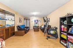 Spacious room featuring wood-finish flooring, a built-in wet bar with mirrored backsplash, and recessed lighting - 