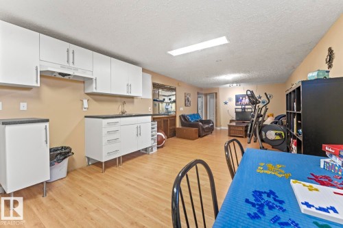Spacious room featuring wood-finish flooring and a light neutral wall color - 4908 59 Street, Cold Lake, AB - Indoor