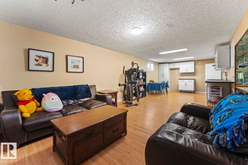 Spacious lower level featuring wood-finish flooring and cream-toned walls - 4908 59 Street, Cold Lake, AB - Indoor Photo Showing Living Room