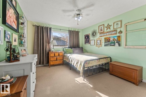 Carpeted bedroom with a window, ceiling fan, and light green walls - 4908 59 Street, Cold Lake, AB - Indoor Photo Showing Bedroom