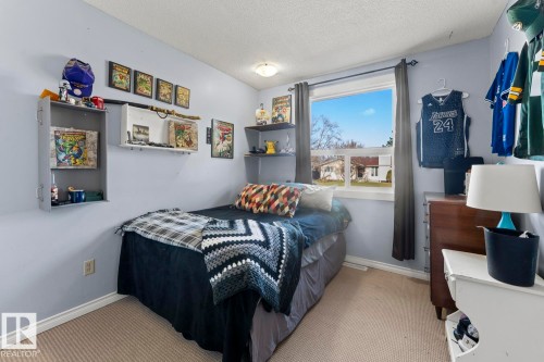 Bedroom featuring carpet flooring, a window with dark drapery, and a ceiling-mounted light fixture - 4908 59 Street, Cold Lake, AB - Indoor Photo Showing Bedroom