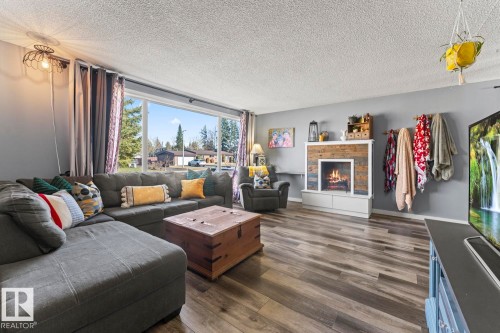 Spacious living area featuring plank wood-finish flooring and a large picture window - 4908 59 Street, Cold Lake, AB - Indoor Photo Showing Living Room