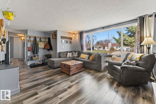 Spacious room featuring wood-finish flooring, a large picture window, and recessed lighting - 4908 59 Street, Cold Lake, AB - Indoor Photo Showing Living Room