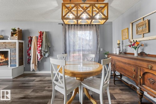 Dining area featuring wood-finish flooring and a contemporary wood chandelier - 4908 59 Street, Cold Lake, AB - Indoor Photo Showing Dining Room