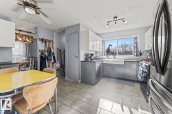 Kitchen featuring white upper cabinetry, gray lower cabinetry, a farmhouse sink, and a large window - 