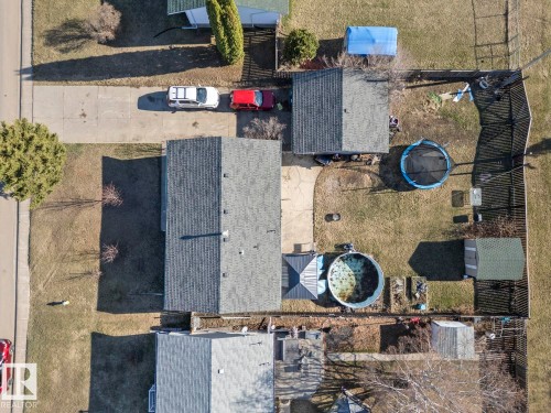 Property featuring a main residence with an asphalt shingle roof, a detached garage with an asphalt shingle roof, a concrete driveway, a privacy fence, and an additional shed - 4908 59 Street, Cold Lake, AB - Outdoor