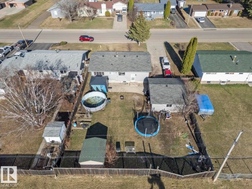 Spacious backyard featuring a wood fence, mature trees, and a detached shed - 4908 59 Street, Cold Lake, AB - Outdoor With View