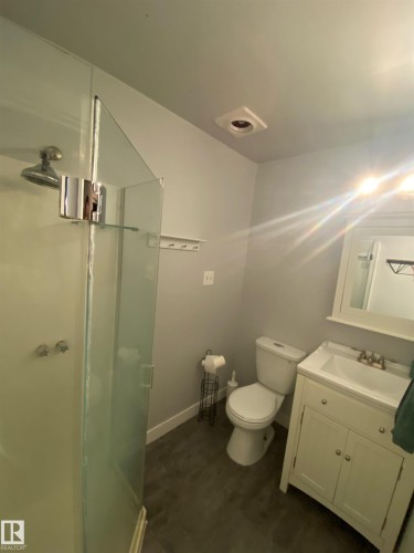 This bathroom features a shower with a glass enclosure, a vanity with a sink, and a toilet - 5030 40 Street, Cold Lake, AB - Indoor Photo Showing Bathroom