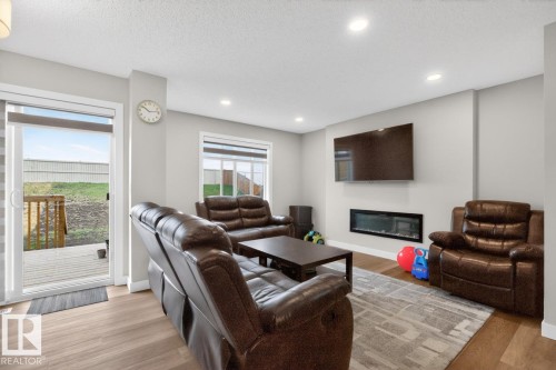 Living area featuring wood-finish flooring, recessed lighting, and an electric fireplace - 3214 9 Street, Edmonton, AB - Indoor Photo Showing Living Room With Fireplace