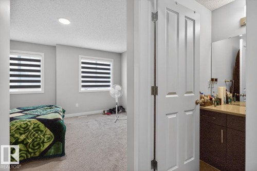 Bedroom featuring two windows with horizontal blinds, overhead recessed lighting, and carpet flooring - 3214 9 Street, Edmonton, AB - Indoor