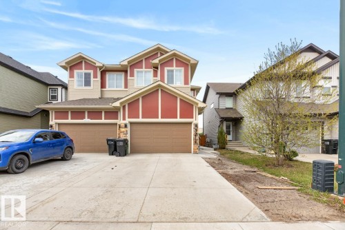 Two-story duplex featuring red siding accents and beige trim - 3214 9 Street, Edmonton, AB - Outdoor With Facade