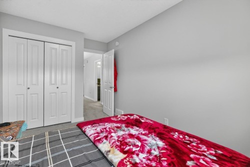 Light gray painted walls define this interior space, featuring a two-panel bi-fold closet and a white interior door with a silver-tone handle - 3214 9 Street, Edmonton, AB - Indoor Photo Showing Bedroom