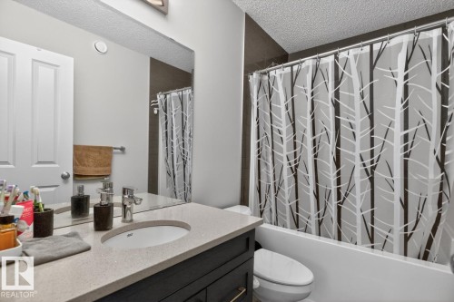 Bathroom featuring a dark wood-finish vanity with a light countertop, an undermount sink, and a chrome faucet - 3214 9 Street, Edmonton, AB - Indoor Photo Showing Bathroom