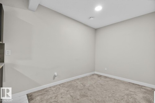 Neutral-toned room featuring a light gray carpet, white baseboards, and a recessed ceiling light - 3214 9 Street, Edmonton, AB - Indoor Photo Showing Other Room