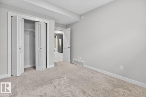 Neutral-toned carpeting extends throughout this interior space - 3214 9 Street, Edmonton, AB - Indoor Photo Showing Other Room