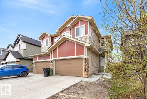Two-story residence featuring a combination of red and beige siding, stone accents, and multiple gables - 3214 9 Street, Edmonton, AB - Outdoor