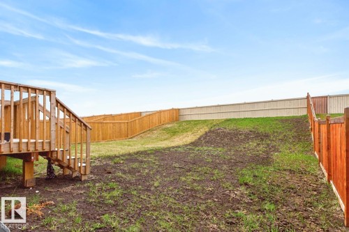 Rear yard with a wooden deck featuring stairs and railing - 3214 9 Street, Edmonton, AB - Outdoor