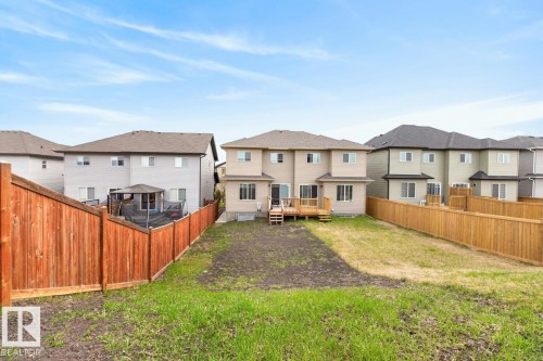 Expansive backyard featuring a partial grass lawn, partial exposed soil, and new wood fencing - 3214 9 Street, Edmonton, AB - Outdoor With Deck Patio Veranda With Backyard With Exterior