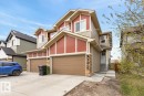 Contemporary duplex with a mixed-material facade featuring reddish-brown siding, light beige horizontal siding, and stone accents - 3214 9 Street, Edmonton, AB  - Outdoor 