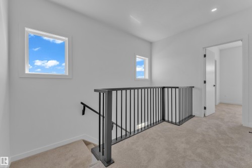 Carpeted hallway featuring a contemporary black metal spindle railing and integrated handrail - 171 Graybriar Drive, Stony Plain, AB - Indoor Photo Showing Other Room