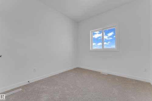 Bright room featuring a window with white trim, light-colored walls, white baseboards, and neutral-toned carpet flooring - 171 Graybriar Drive, Stony Plain, AB - Indoor Photo Showing Other Room