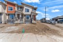 Contemporary townhome exterior featuring multi-toned siding, stone accents, and a distinctive sloped roofline - 171 Graybriar Drive, Stony Plain, AB  - Outdoor With Facade 