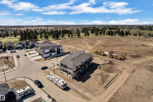 Modern residential development featuring multi-story homes with dark roofing and light-colored siding - 171 Graybriar Drive, Stony Plain, AB - Outdoor With View