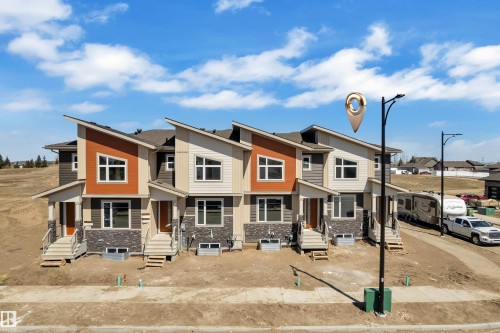 Modern townhome exteriors featuring varied siding, stone accents, and distinct rooflines - 171 Graybriar Drive, Stony Plain, AB - Outdoor With Facade
