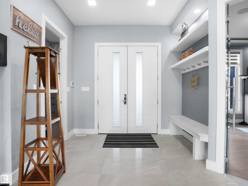 Double entry doors with frosted glass panels, complemented by large format tile flooring - 913 Wood Place, Edmonton, AB - Indoor Photo Showing Other Room