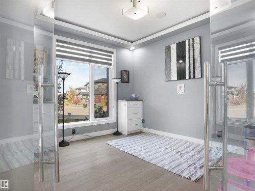 Room featuring a large window with horizontal blinds and light wood-finish flooring - 913 Wood Place, Edmonton, AB - Indoor