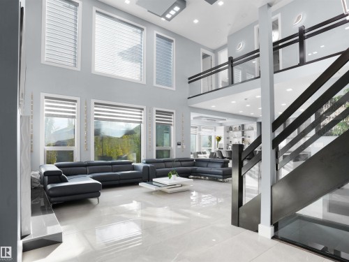 Two-story living area with high ceilings, large windows featuring blinds, and polished tile flooring - 913 Wood Place, Edmonton, AB - Indoor