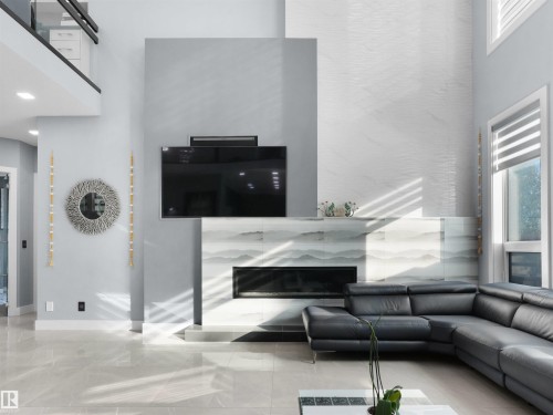 Two-story living area featuring a contemporary fireplace with a tiled surround - 913 Wood Place, Edmonton, AB - Indoor With Fireplace